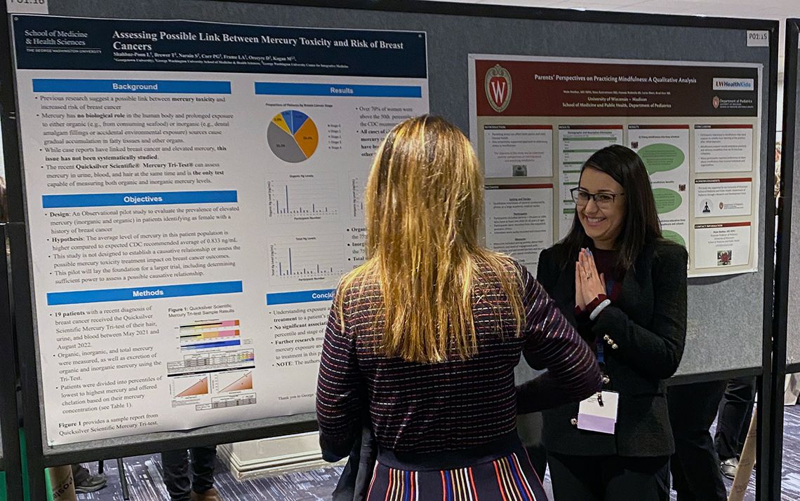 Two women stand in front of research posters